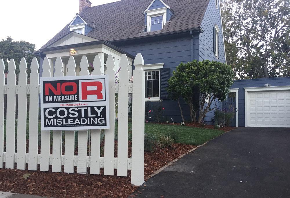 A Burlingame resident stakes a sign in their front yard reading 