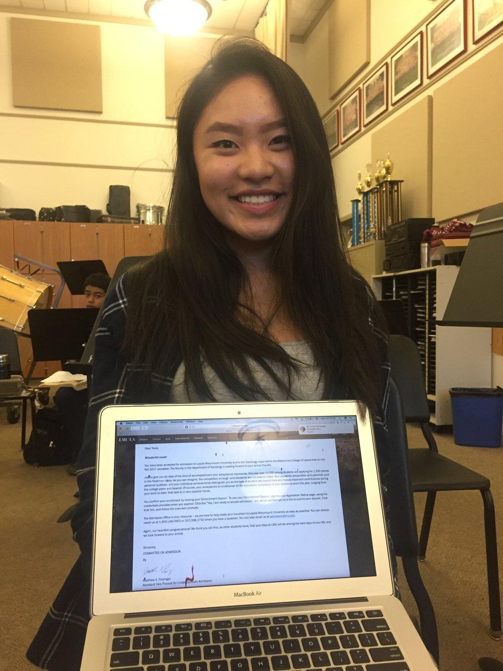  Senior Tesia Cheung holds up a letter of acceptance to Loyola Marymount University 