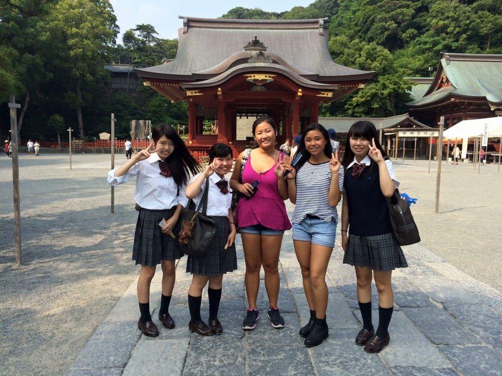  Erin Woo and Larissa Qian pose with Kanto Daichi High School students at a temple in Kamakura, Japan. 