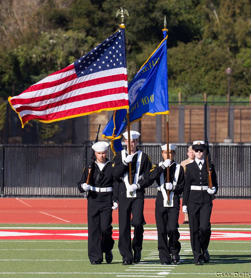  Junior Lilli Hirth (far right) and three other Sea Cadets parade the colors during the national anthem at a college football game. 