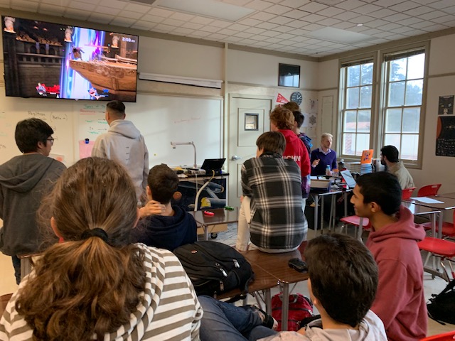 Members of the club watch in excitement as two students battle in a tournament match.