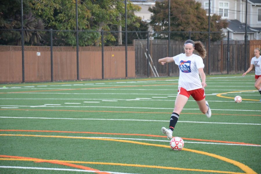 Sophomore Ella Bradley prepares to shoot during the soccer tryouts.