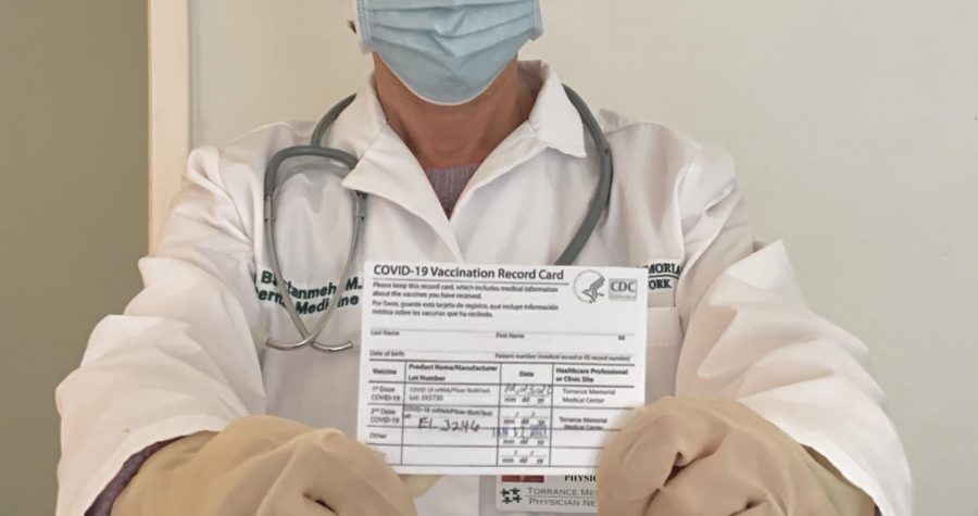 Hiva Bastanmehr, a physician, holding her COVID-19 vaccination record card to show proof of vaccination against the virus. 