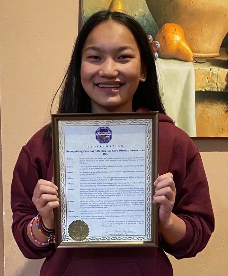 Junior Rachel Burdick proudly presents the official proclamation from the City of Burlingame recognizing the last day of February as Rare Disease Day.
