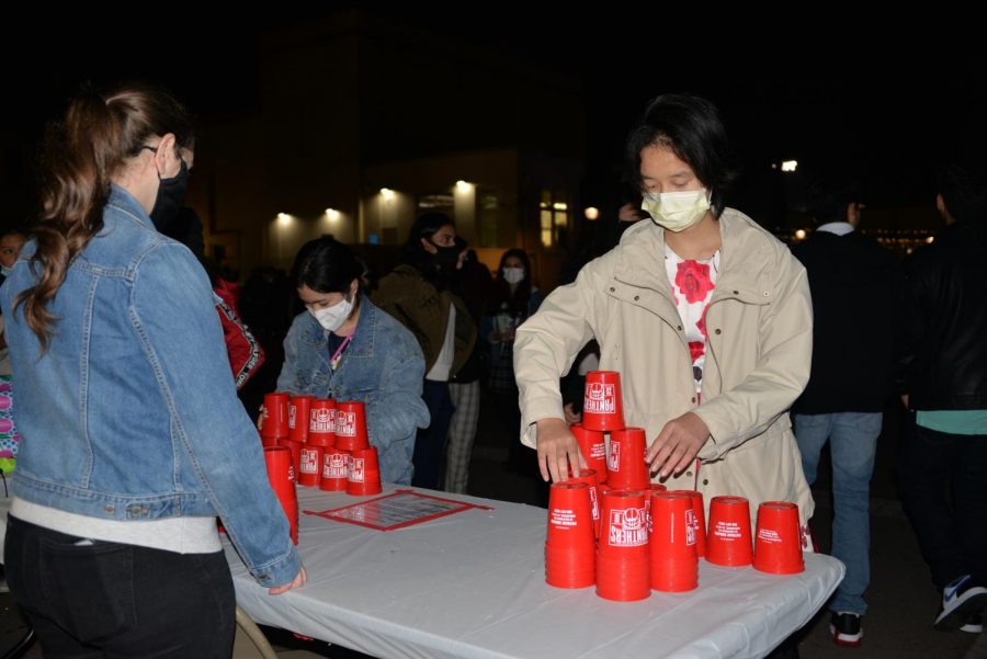 Students participate in the cup-stacking challenge, one of many carnival games offered at the HOCO Dance and Festival.
