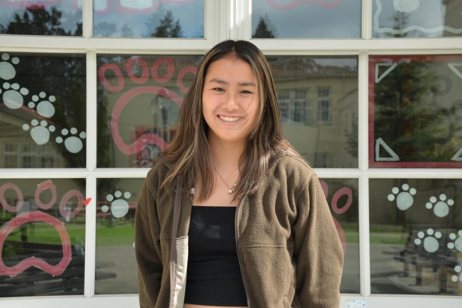 2022-2023 ASB President Rinko Miyoshi stands in front of the leadership class’s window reflecting Burlingame High School.