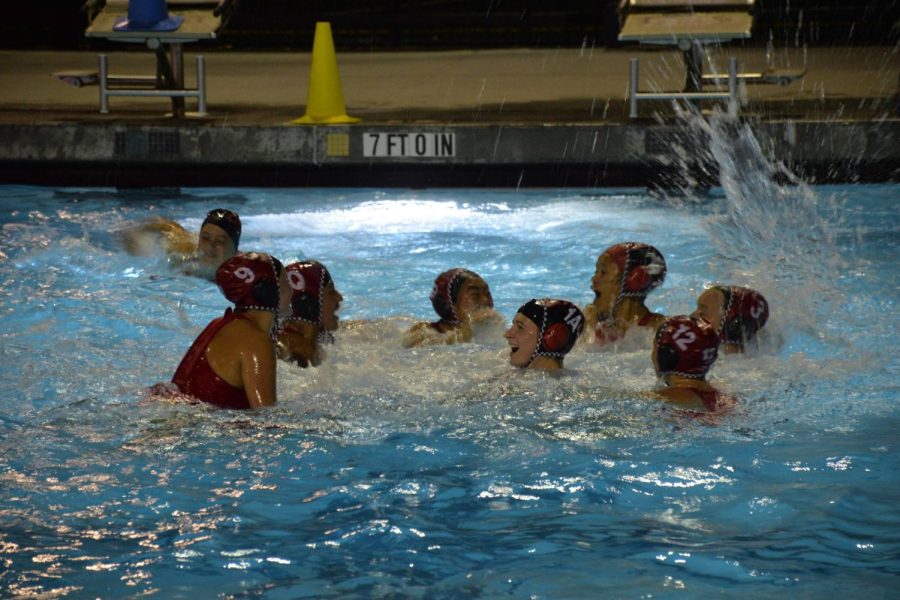 The girl’s varsity water polo team celebrates in the water as the game ends and the Panthers claim their momentous victory against Menlo-Atherton.