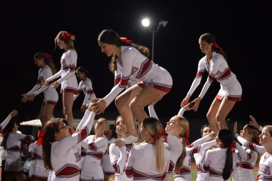 The+cheer+program+prepares+for+a+team+stunt+during+the+football+game+on+Oct.+7.