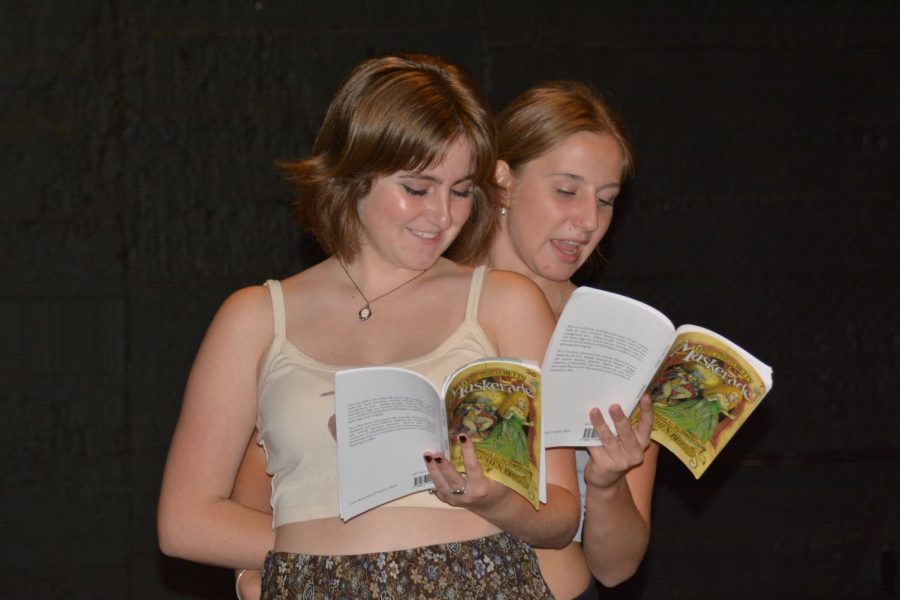 Mrs. Plinge, played by senior Kalla Kamenov (Left), and Nanny Ogg, played by senior Ayden West (Right), smile jovially as they hold their “Maskerade” scripts during one of the first rehearsals.