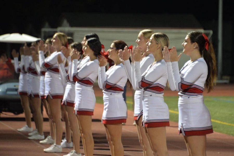 The cheer team uplifts the student section by performing engaging stunts and chants.