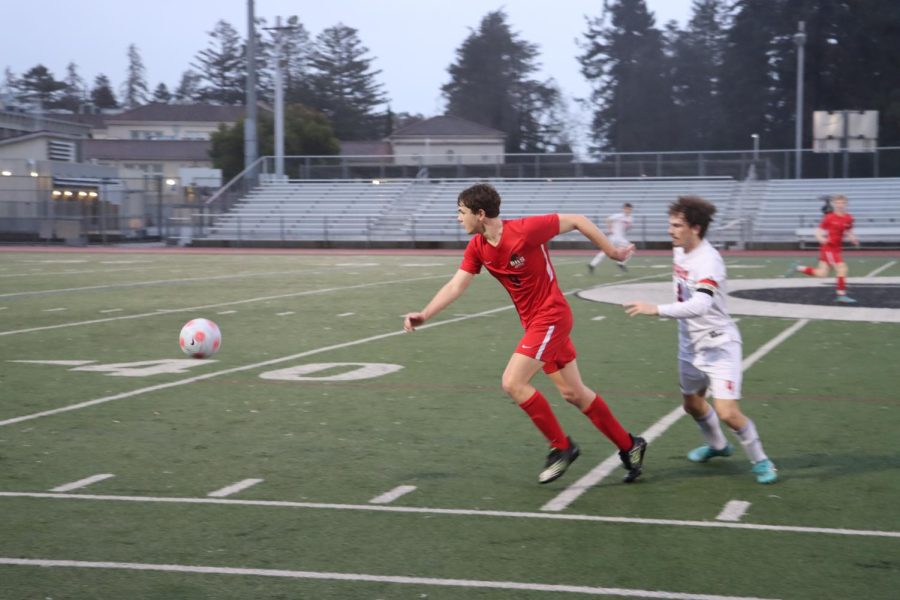 Senior Striker Sean O’Grady looks for passing options after receiving a pass in boys’ soccer’s league opener on Jan. 11.