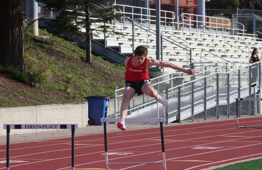 Junior Jake Rothstein leaps during the varsity 300-meter hurdles event, finishing in second place.