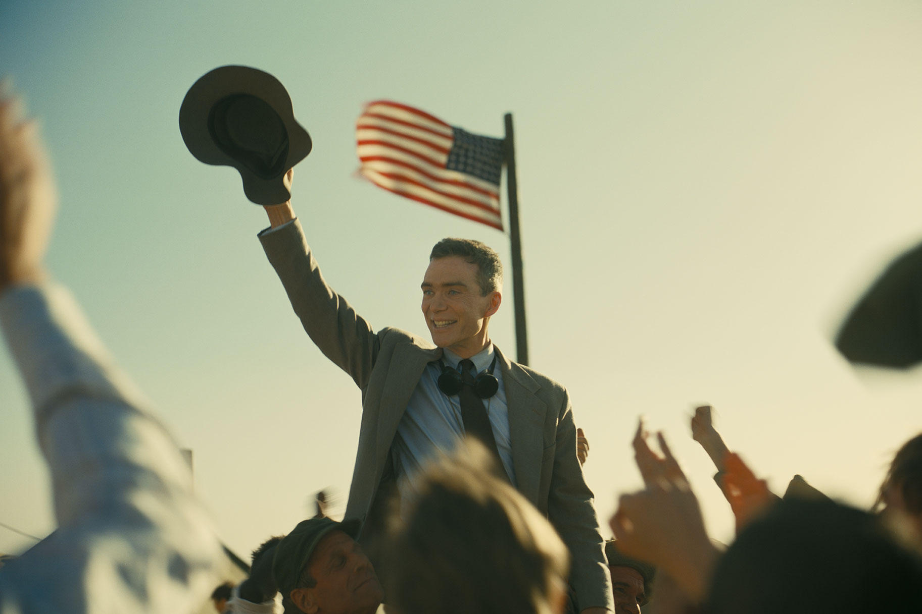 Oppeneheimer (Cillian Murphy) cheers with the American public at the Los Alamos lab following the bombing of Japan.