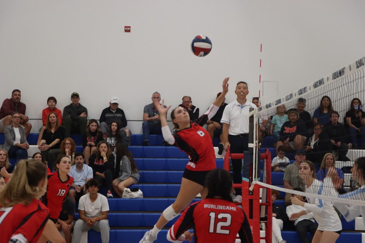 Sophomore Ava Scatena rises to spike the ball to Hillsdale during their matchup on Sept. 12. A second-year varsity player, Scatena is one of three underclassmen on the squad.