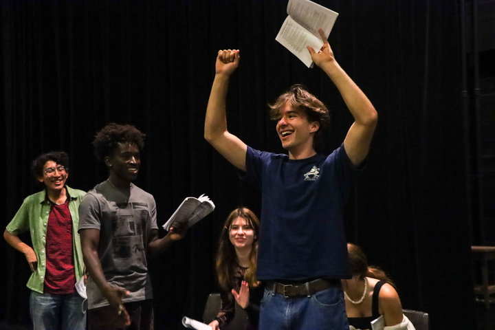 Senior Dylan Ares Hansen raises his arms in victory during rehearsals for the fall play.