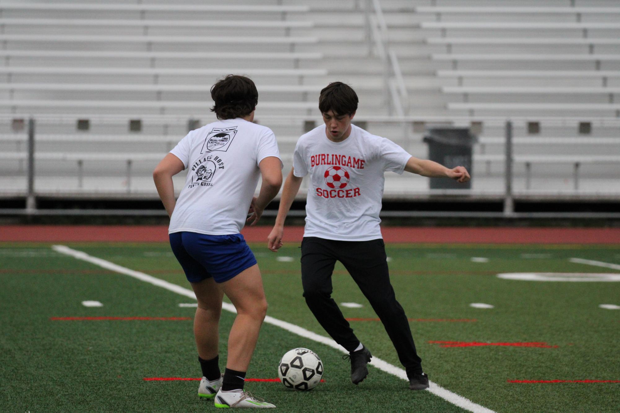 Junior Dylan Aaronson dribbles the ball during warm ups at practice on Nov. 15. 
