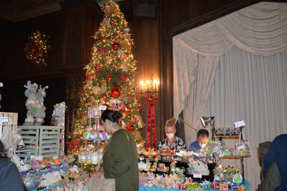A customer looks at soaps displayed next to one of many Christmas trees at the event. 