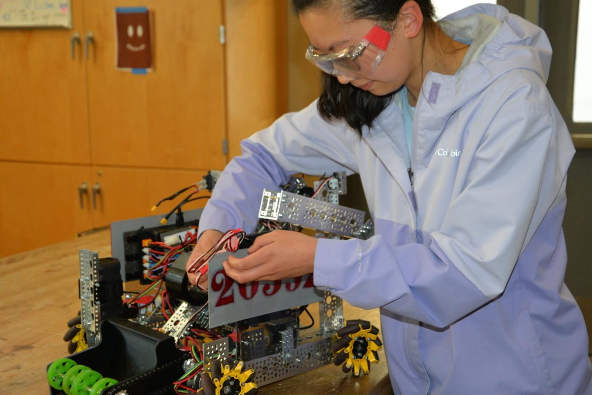 Renne Pi, a first-year member of the FTC team, adds the final adjustments to the robot they built for the recent competition held on December 2nd.