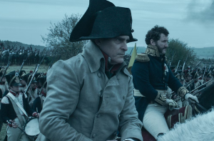 Napoleon Bonaparte (Joaquin Phoenix) stands alongside his French army, waiting to strike against the British troops in the Battle of Waterloo.