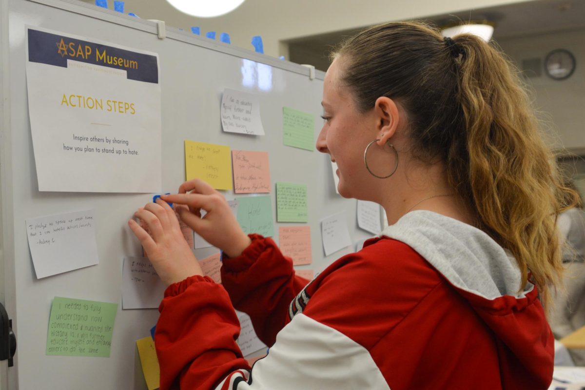 Sophomore Paige Altbaier posts her pledge to stop hate at ASAP’s most recent exhibit in the alumni room on Friday, Jan. 26. 