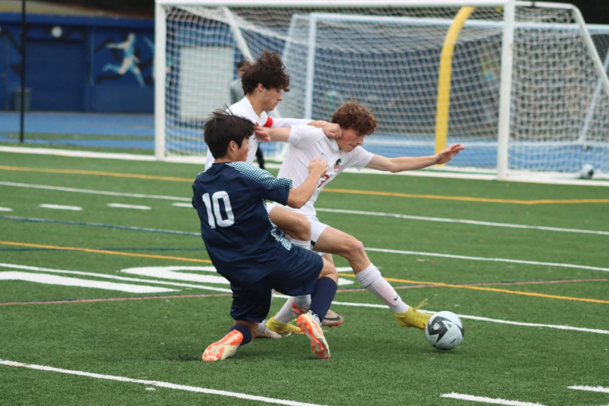 Burlingame defenders senior Hank Lane and Charlie Lane fight off a Carlmont attacker during their league match against Carlmont on Jan. 12.