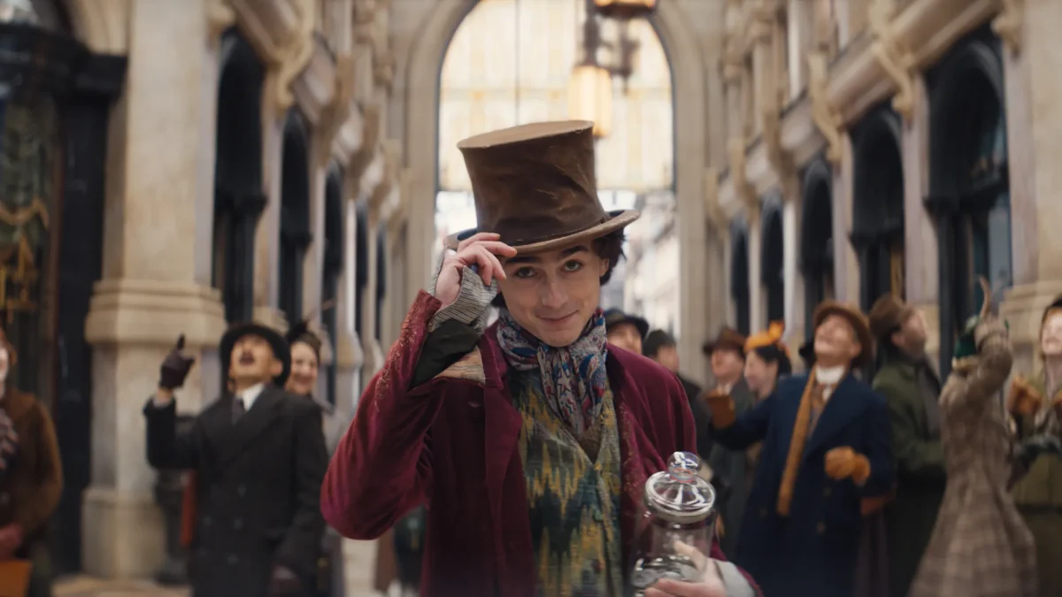 Willy Wonka (Timothée Chalamet) tips his hat in the newest kids and family musical, “Wonka.”