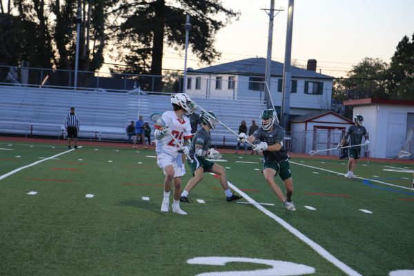 Freshman Dylan Black searches for an open teammate during the boys’ lacrosse game against Palo Alto on Tuesday, April 9.
