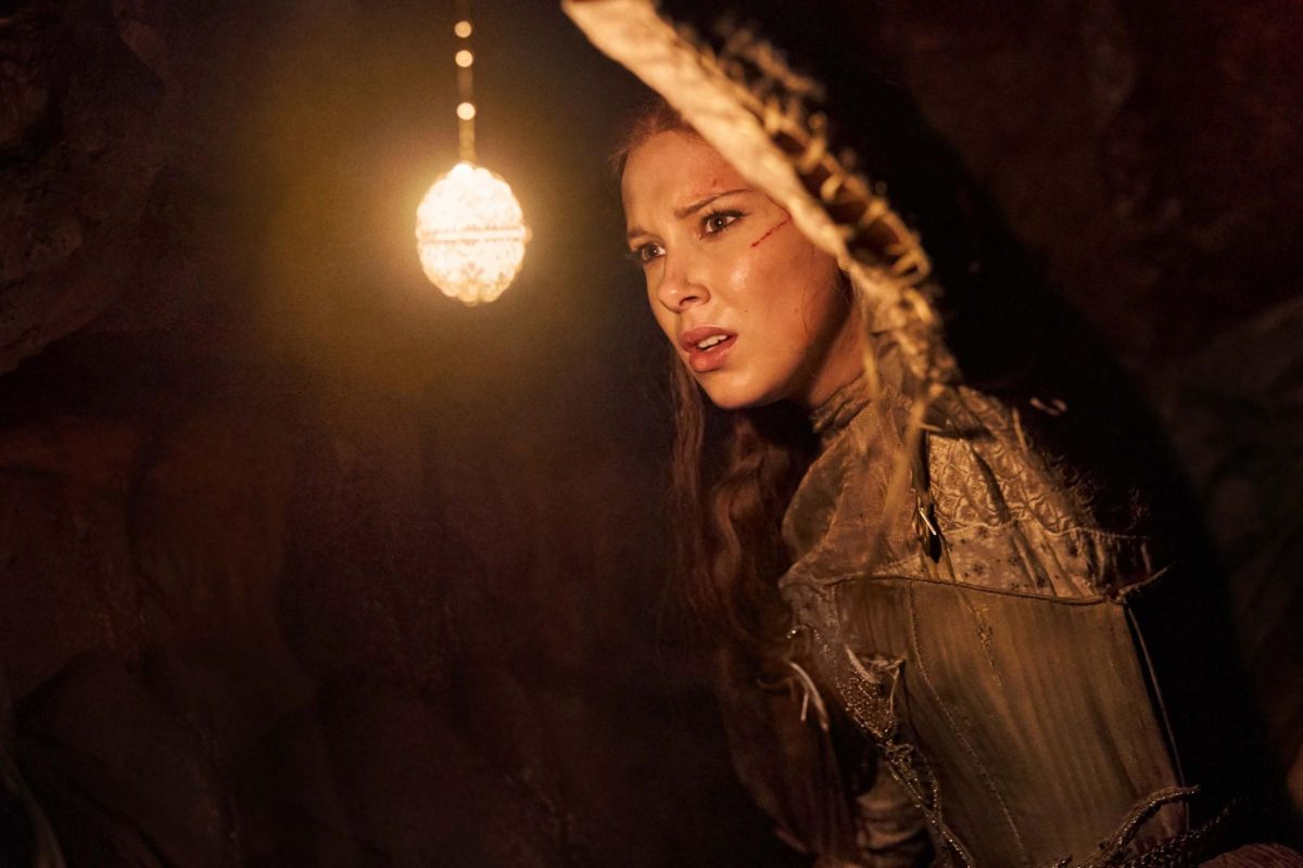 Elodie (Millie Bobby Brown) shines a light as she adventures through the cave.