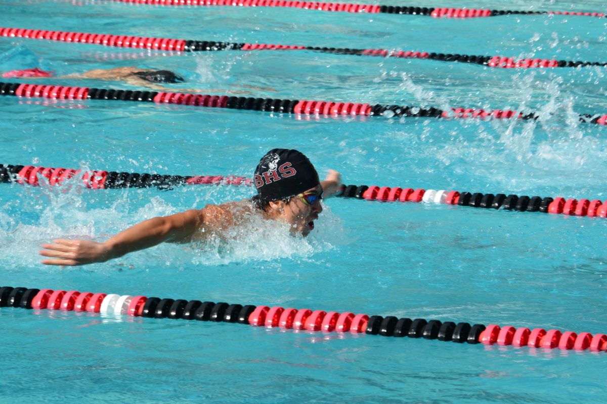 Sophomore Kieran Clarke takes a deep breath as he swims butterfly in his race. 