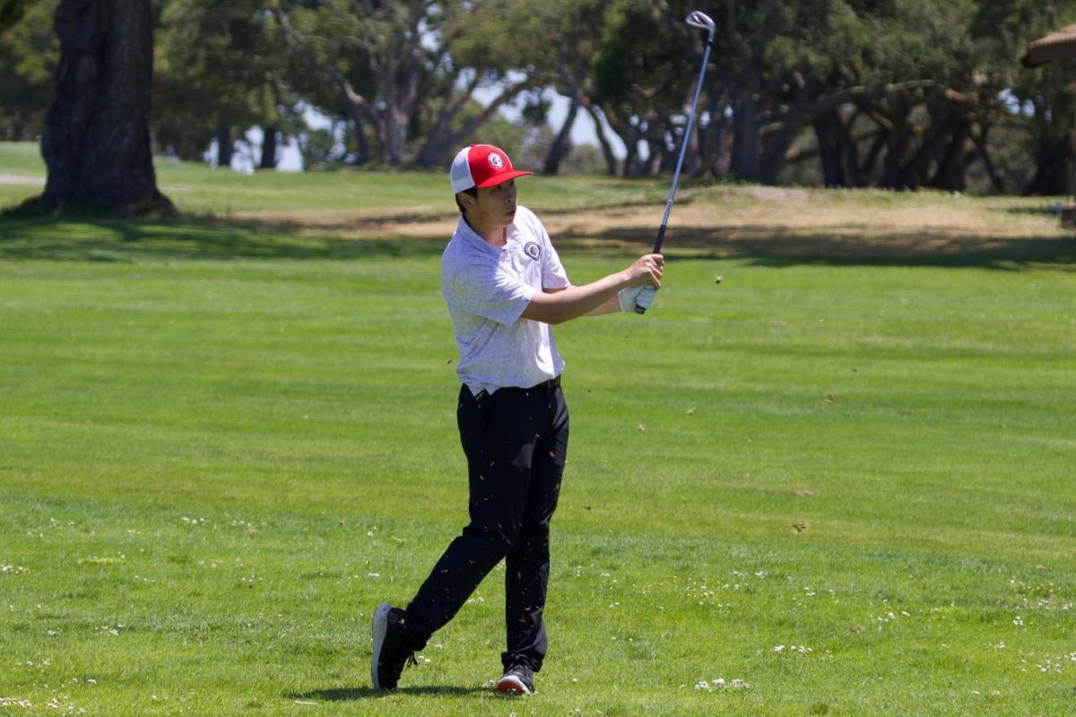 Senior Clayton Lau hits an iron shot out of the rough on the 4th hole at Laguna Seca Golf Ranch on May 14.