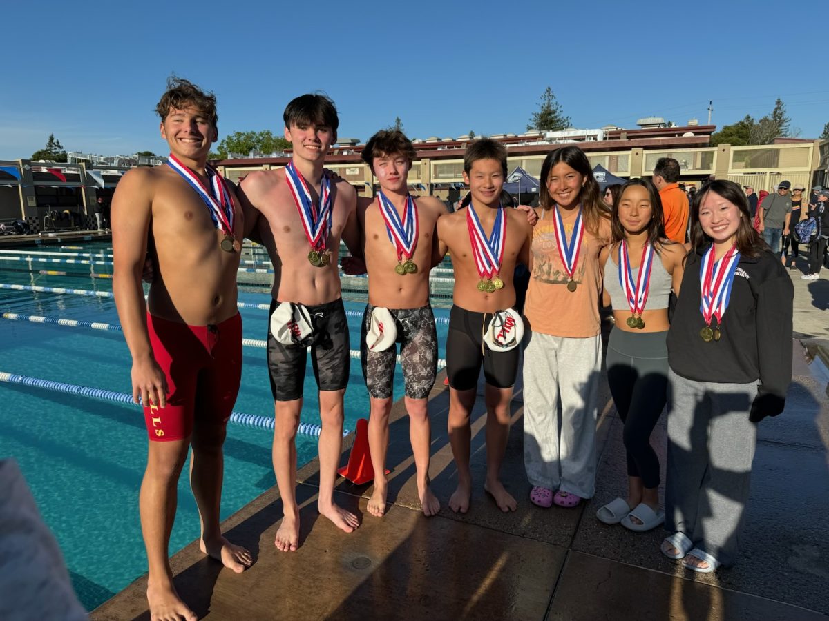 Senior captain Sofia Kim and junior Karena Huang pose with swimmers from Mills High School after earning their medals.