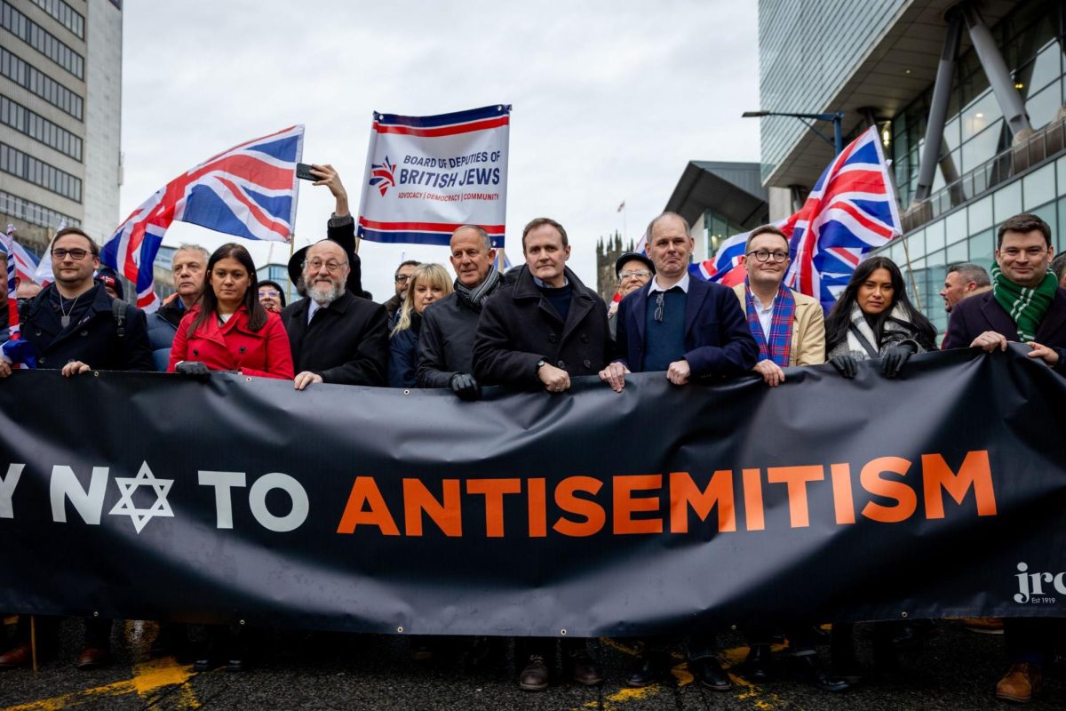 British security minister Tom Tugendhat marches with citizens during a British march against anti-semitism.