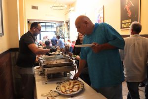 Customers grab plates of Italian food during the lunch buffet on Friday, Aug. 23.