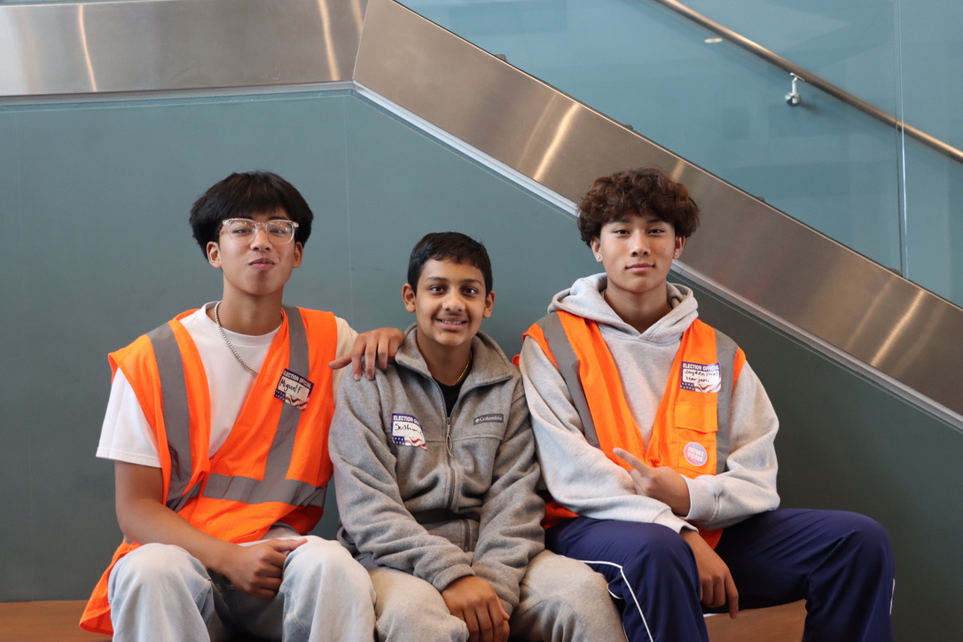 Burlingame student volunteers Jayden Harjani and Miguel Fernandez pose with Mills student Sushim Chakrabortty at the Burlingame Community Center polling site.