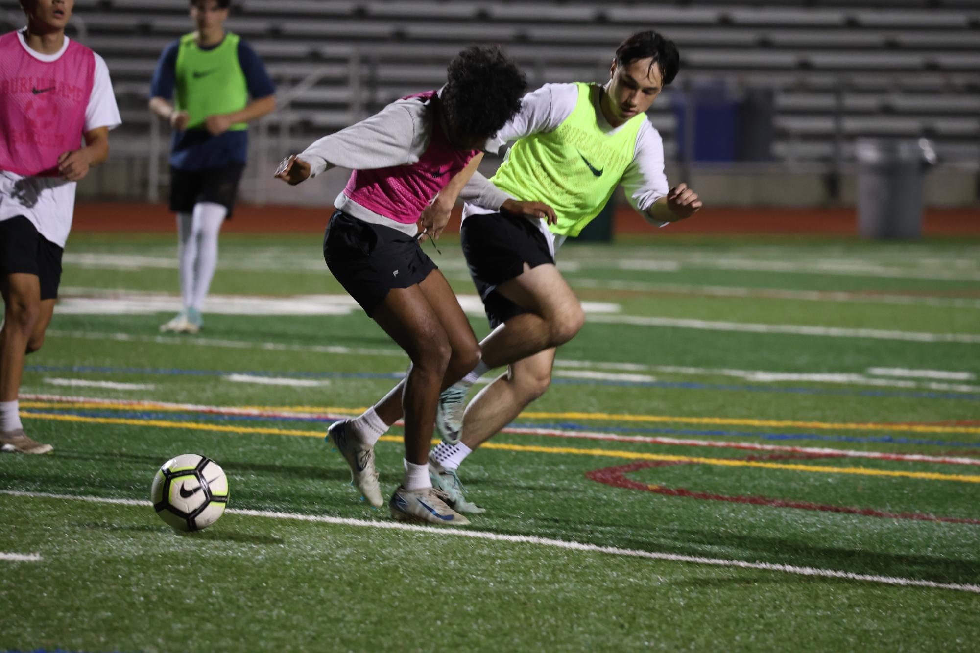 Sophomore Ayaan Palaniappan and junior Jack Clarke battle to gain possession of  the ball during soccer tryouts. 