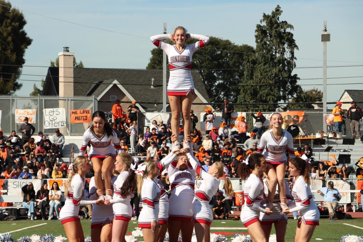 Senior Lucy Istock and juniors Eva Mercer and Katie Trevor begin the highly anticipated pyramid stunt. 