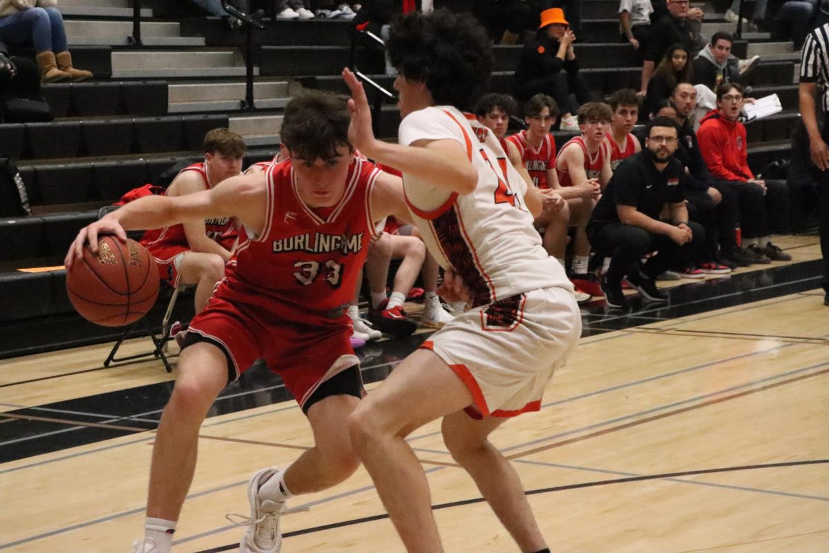 Freshman forward Lucca Maher drives on the baseline against a Woodside defender. Maher finished the game with a team-high 21 points.