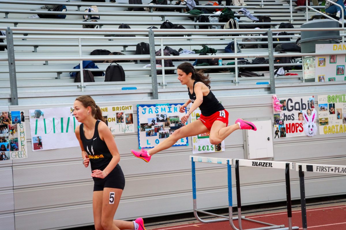 Sophomore Avery Browdy leaps over a hurdle in the women's frosh-soph 100m hurdle event. 