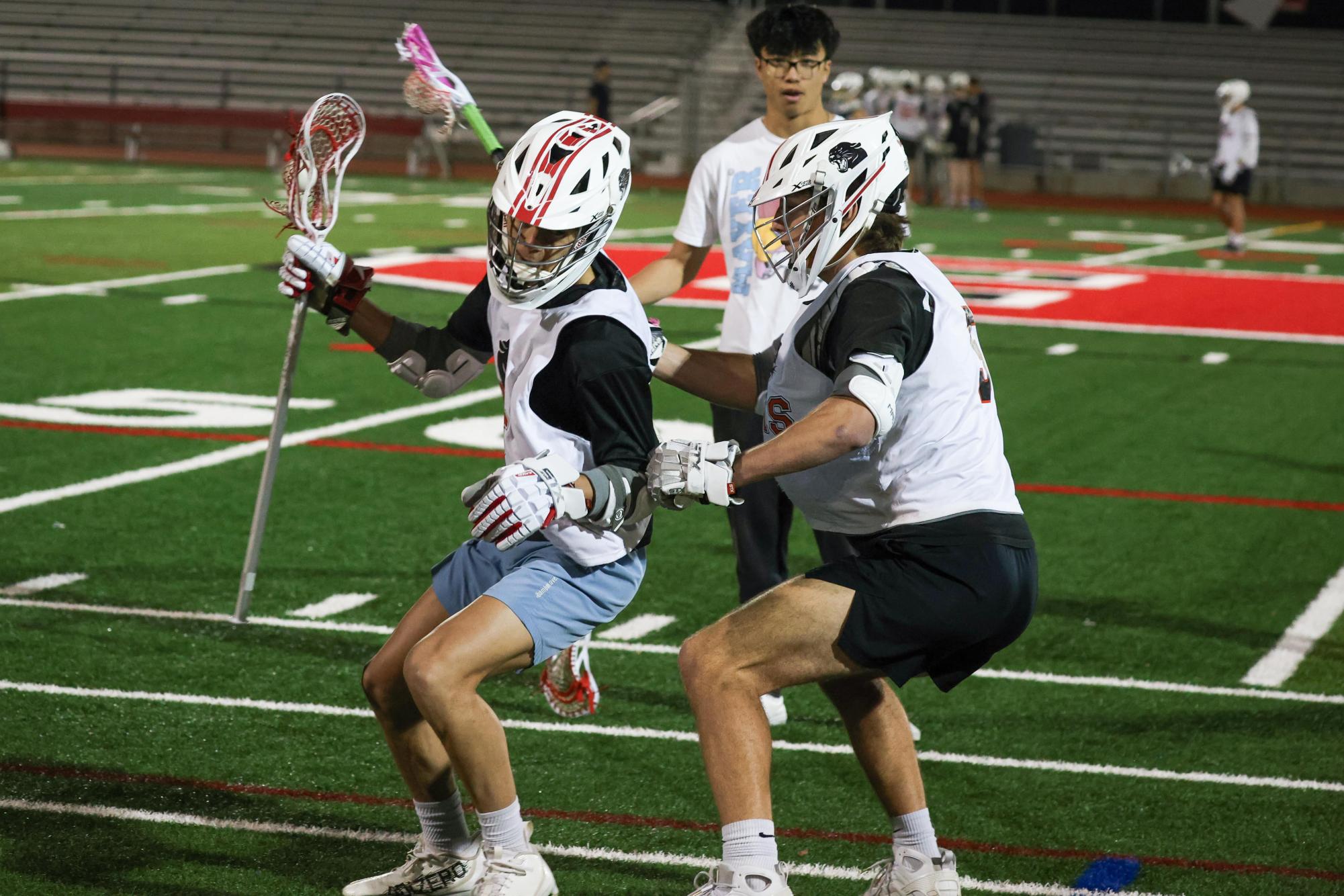 Junior defender Oscar Bill lays a check on senior midfielder Roman Karp during a drill. 