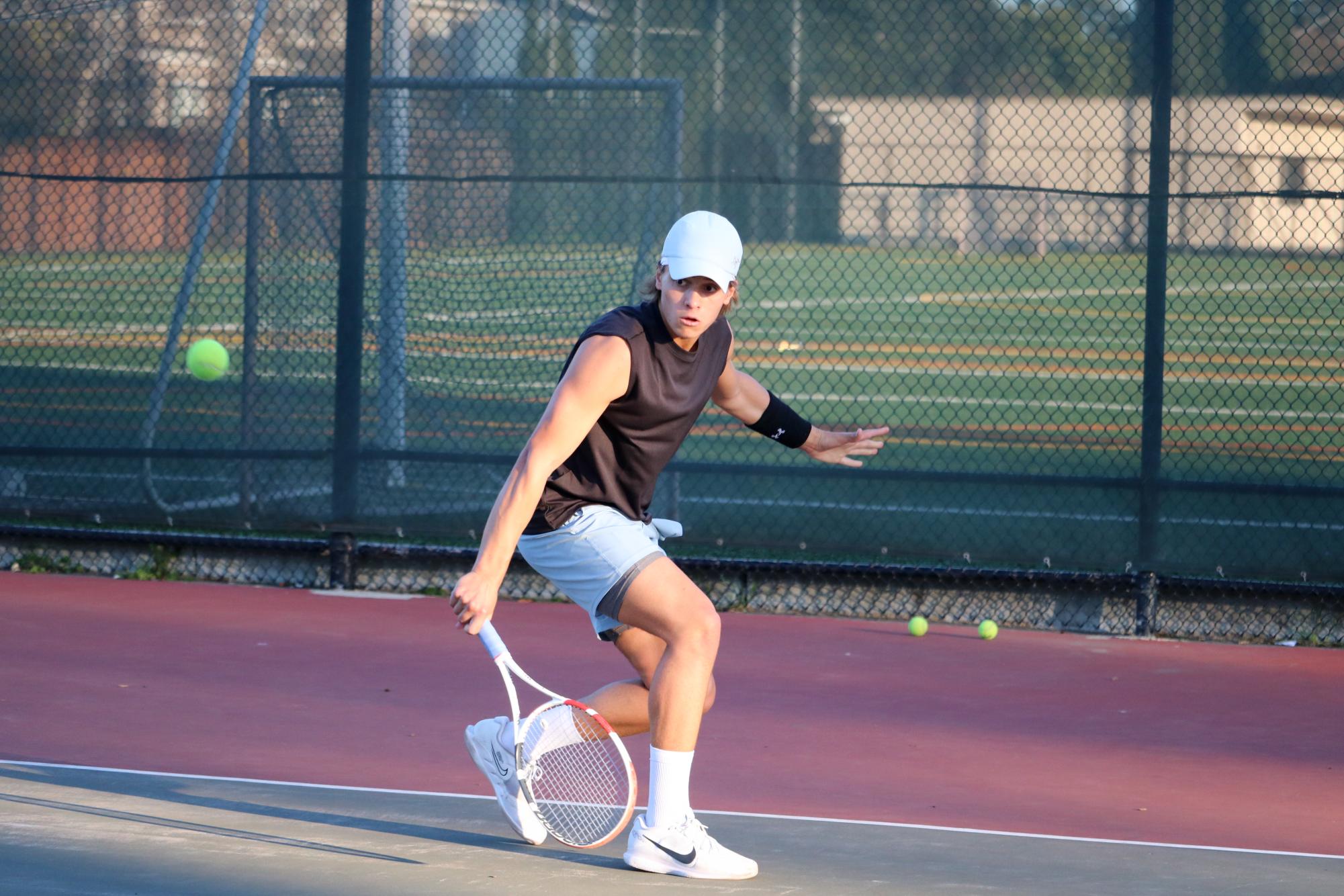 Junior Alex Bozinovic hits a backhand slice in singles practice.