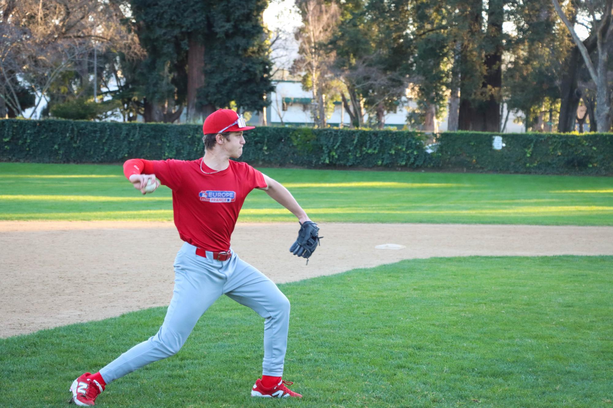 Junior Ea Leialoha fields a ground ball during a drill, throwing from third to first base. 