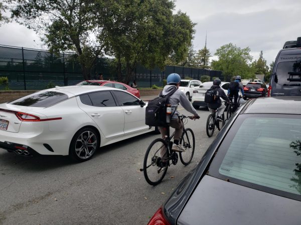 Students seen biking alongside cars on a busy road without safe bike lanes, a situation Safe Routes to School hopes to resolve.