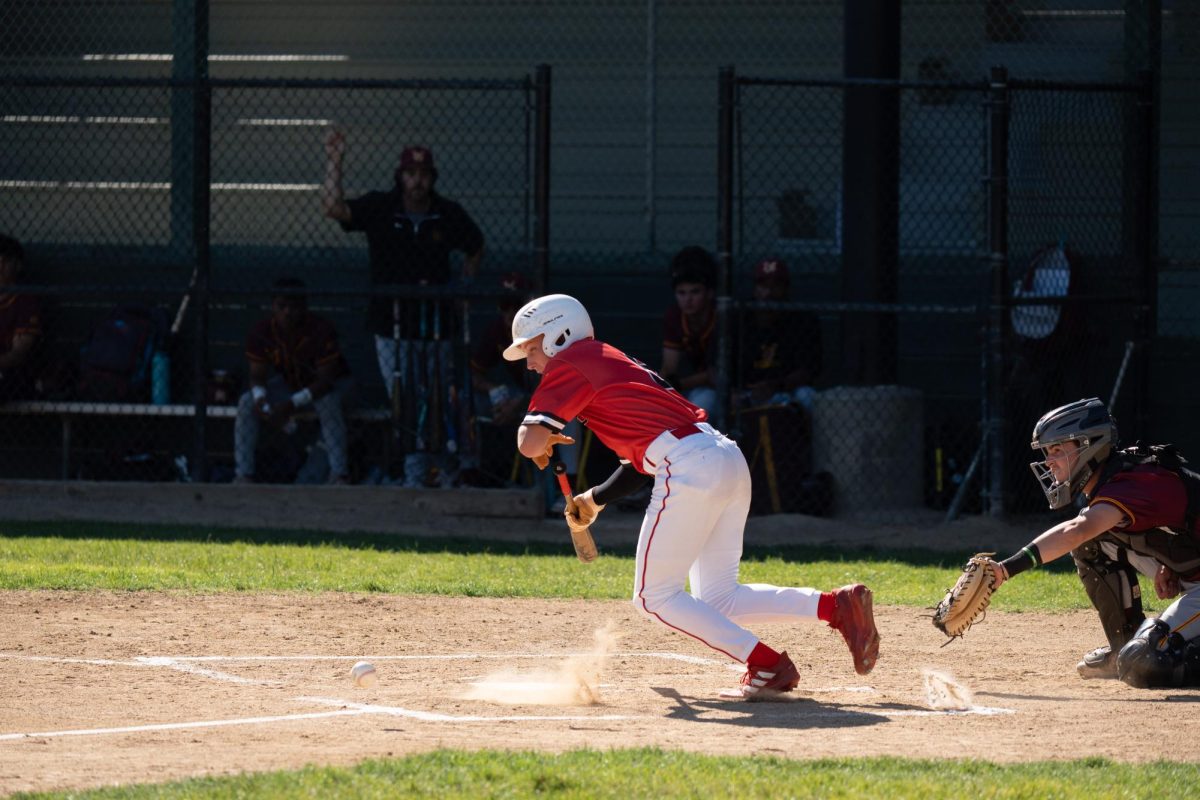 Junior Grayson Howard lays a bunt down the third base line.