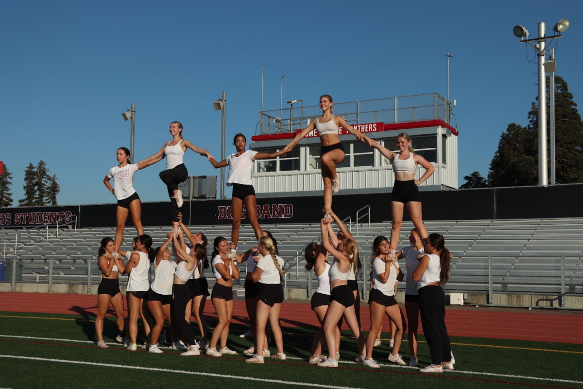 Varsity cheer practices their stunting in preparation for their halftime performance.