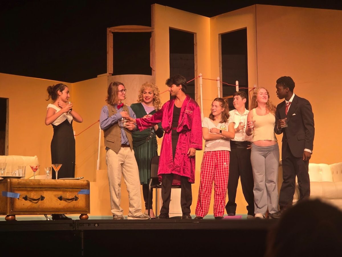 The “Rumors” cast, still in character, gather to celebrate a victorious moment.