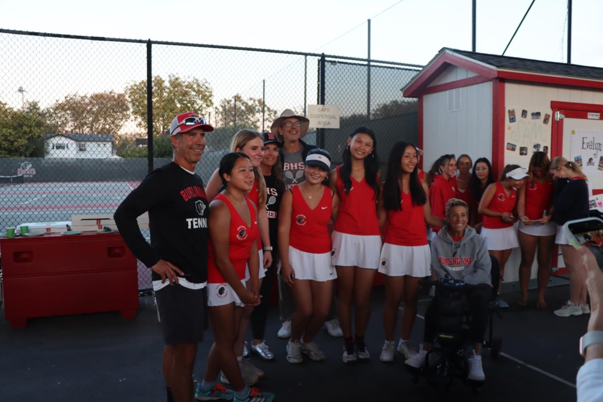 Seniors Lyra Sheng, Scarlett Gemmer, Katie Jarrett, Sam Tom, and Evelyn Du line up with their coaches after the senior night ceremony.