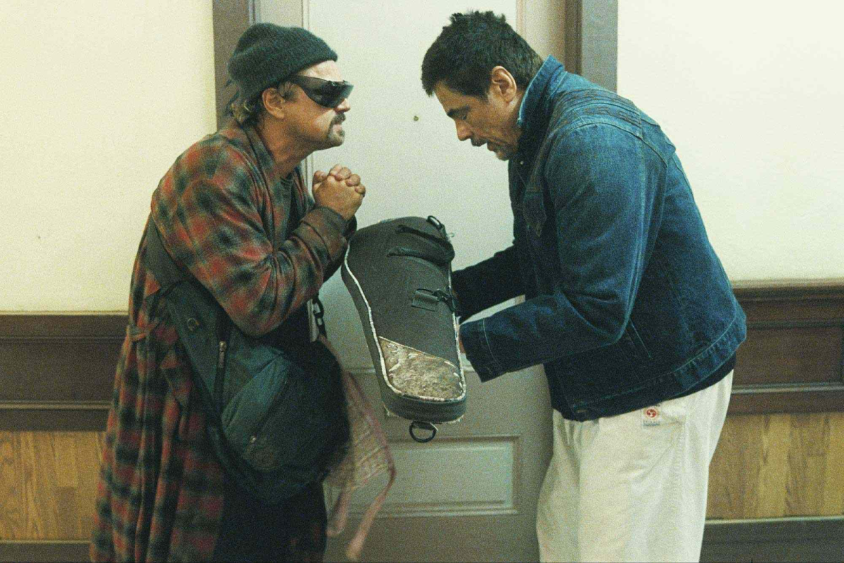 Pat Calhoun (Leonardo DiCaprio) accepts a rifle from Sergio St. Carlos (Benicio del Toro) for protection as he sets out to look for his daughter.