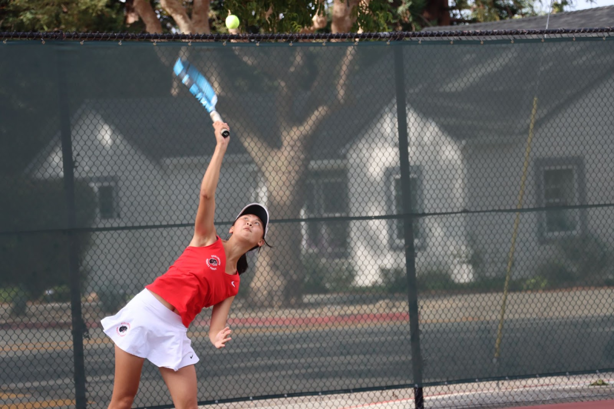 Senior Samantha Tom hits a serve to the opposing player.