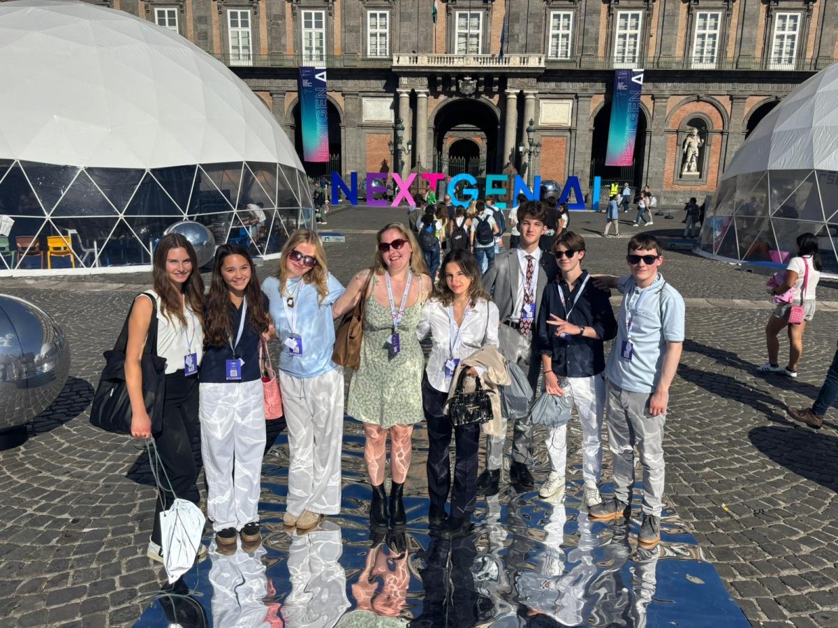 Juniors Sophia Weber and Caroline Rafferty gather with other NextGen summit delegates to take a photo.