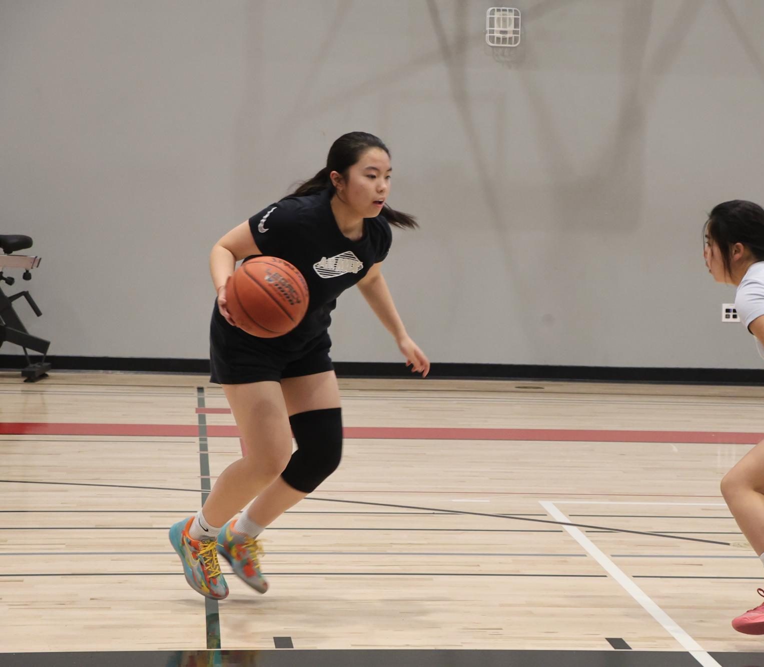 Junior Megan Chiu prepares to dribble around junior Maya Siu during practice on Nov. 14.